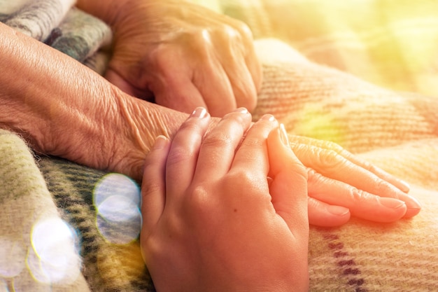 Caregiver, carer hand holding elder hand