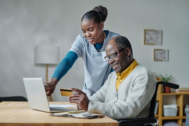 Caregiver explaining man to pay online