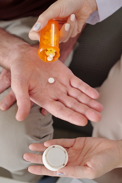 Photo caregiver giving medicine to patient