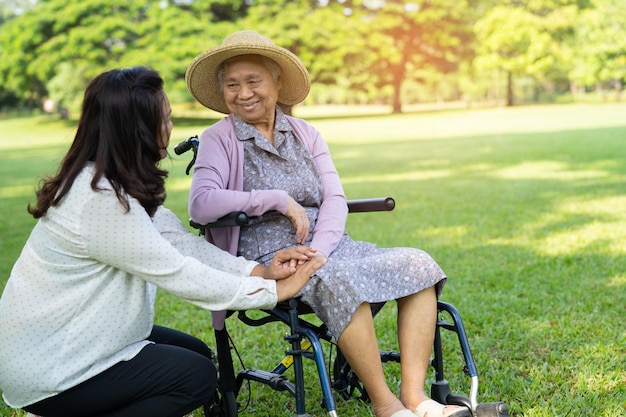 간병인의 도움과 보살핌 아시아 노인 여성은 건강이 좋은 보행기를 사용합니다.