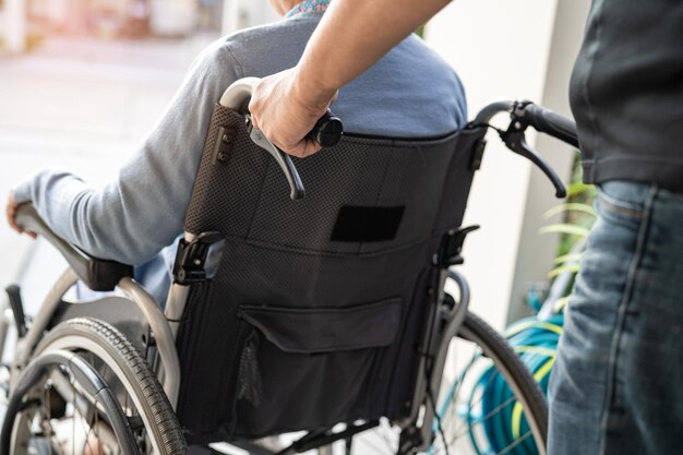 간병인의 도움과 간호 아시아 노인 또는 노인 여성 환자는 간호 병원 병동에서 휠체어에 앉아 건강하고 강력한 의료 개념