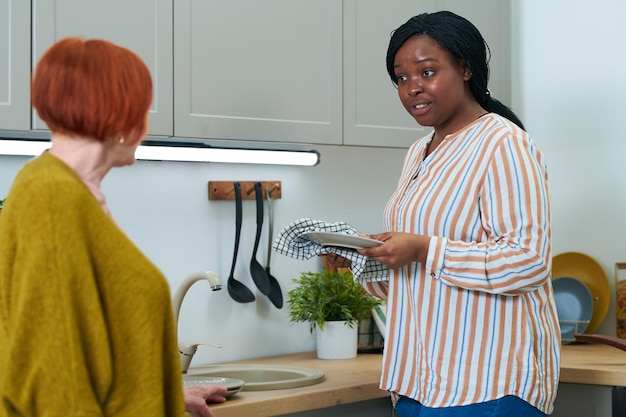 Caregiver helping elderly woman with chores