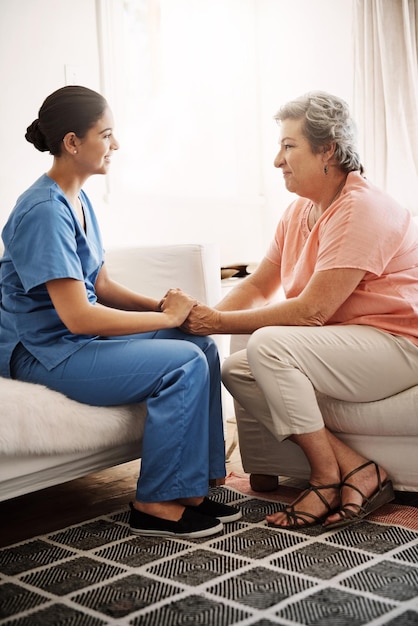 caregiver woman and holding hands of support in clinic for patient support sympathy or empathy by consultation of medical results healthcare trust or hope of counselling together at nursing home