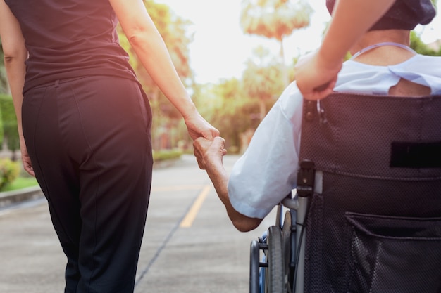 Caretaker and daughter with patient in wheelchair 