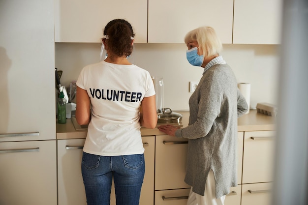 Caretaker helping an aged lady with chores