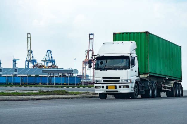 Camion portacontainer verde del carico nella logistica del porto della nave. industria dei trasporti nel concetto di affari del porto.