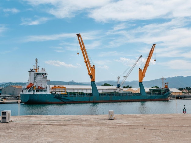 Cargo ship with cranes on loading in the port