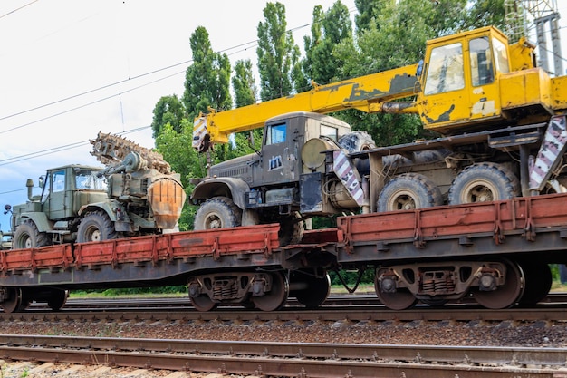 Photo cargo train carrying military vehicles on railway flat wagons