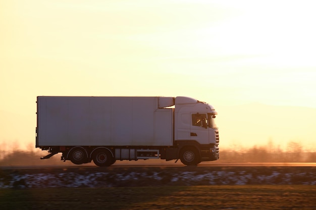 Cargo truck driving on highway hauling goods in evening Delivery transportation and logistics concept