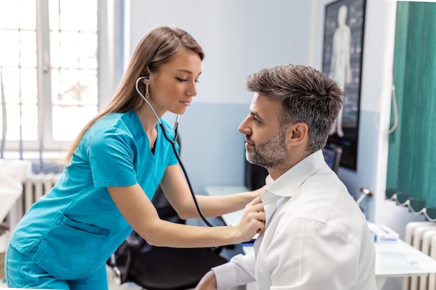 Caring Caucasian female doctor use phonendoscope examine male patient heart rate at consultation in hospital Woman nurse or GP use stethoscope listen to man heartbeat in clinic