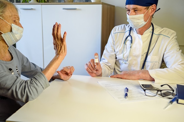 Medico premuroso aiuta una nonna anziana negativa di 85 anni, una paziente a casa o in ospedale.