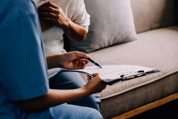 Photo caring doctor teaches female patient to use mobile healthcare app retired lady sitting in hospital exam room looking at cell screen learning to download health tracker for senior citizens copy space