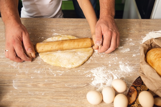 Caring father help little preschooler son prepare cookies, smiling loving dad learn cooking with small boy child, making lunch on weekend in kitchen together