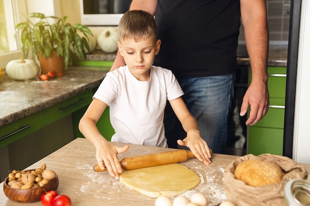 Il padre premuroso insegna a suo figlio a cucinare. attività indoor. ottimo tempo con la famiglia