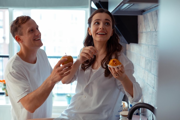 Caring loving husband giving apple to his lovely wife