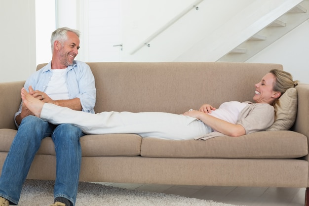 Caring man giving his partner a foot rub on the couch