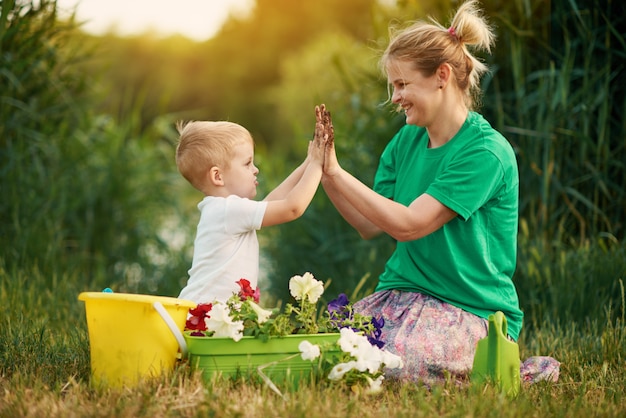 Prendersi cura della natura. madre e figlio che piantano piantina in terra su assegnazione sulla sponda del fiume. concetto di botanica ed ecologia.