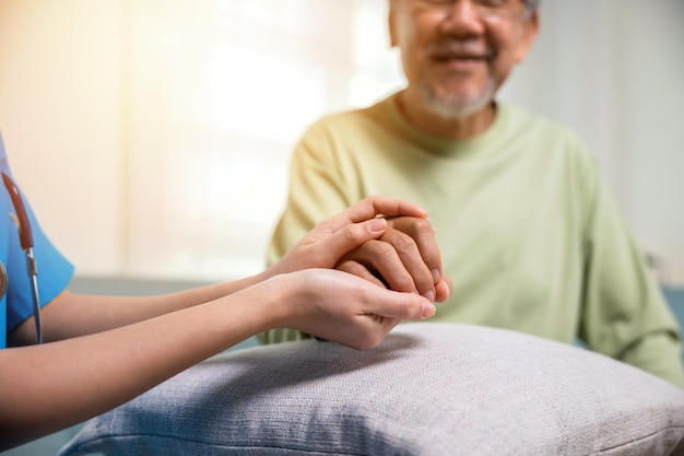 Caring nurse helping elderly old man care facility gets help