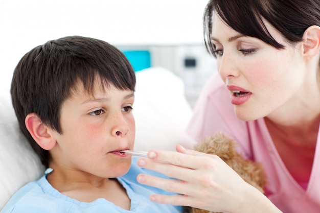 Caring nurse taking her patient's temperature 