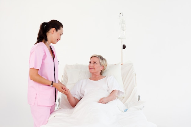 Caring nurse with her elderly patient 