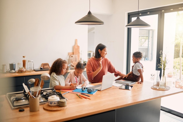 caring parent tutoring and teaching her small children with after school activity loving mother taking care of young kids and helping with class homework projects in the kitchen of their family home