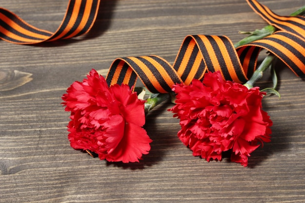 Carnations and St George's ribbon on grey wooden background