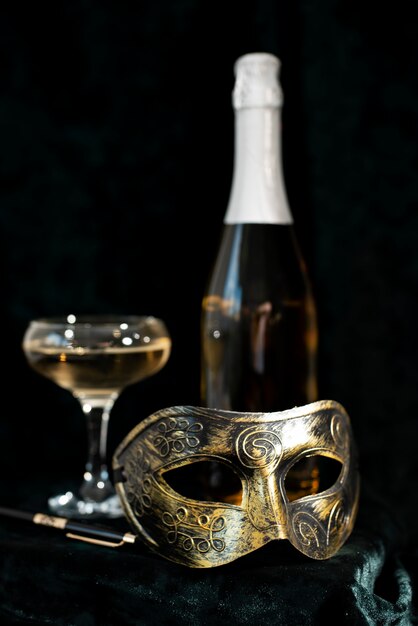 Carnaval-masker voor een glas wijn en een fles