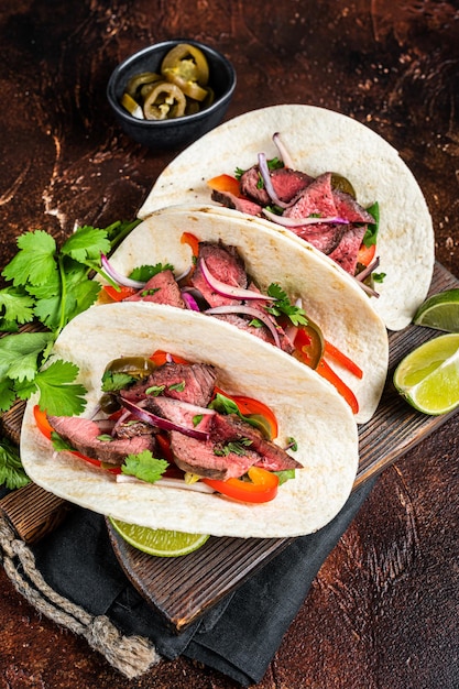 Carne Asada Tacos with 구운 스테이크 그린 소스 할라피뇨와 양파 멕시코 음식 어두운 배경 상단 보기