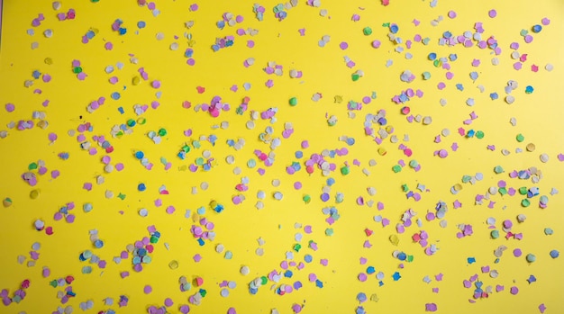 Carnival or birthday party confetti on bright yellow background