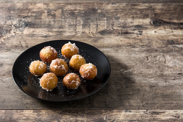 Photo carnival fritters or buñuelos de viento on wooden table