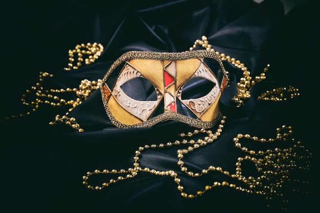 Carnival mask on black satin background