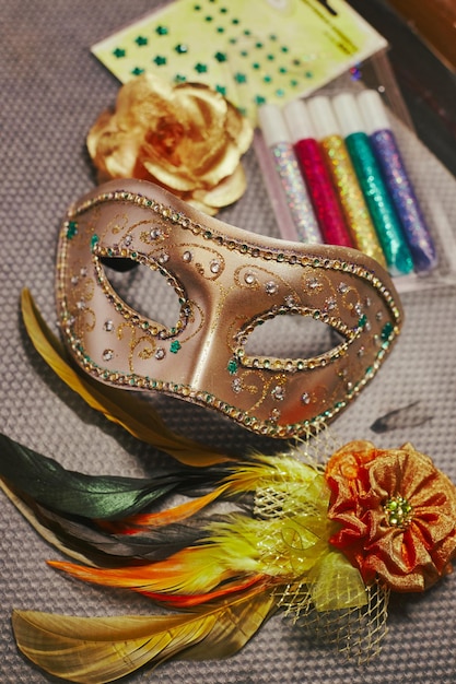 Maschera di carnevale in fase di decorazione e materiali per la sua decorazione maschera per mascherata fai da te