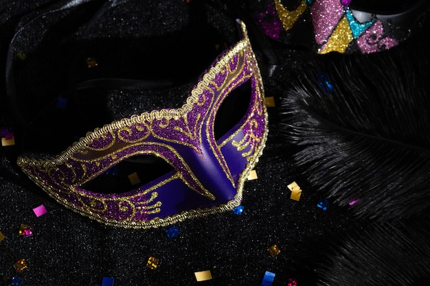 Carnival mask with confetties on black background