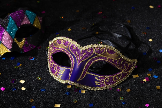 Foto maschera di carnevale con confetti su sfondo nero