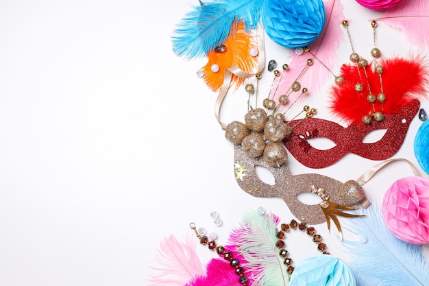carnival masks and feathers on white background space for text