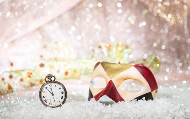 Carnival party Minutes to midnight on an old watch colorful mask bokeh festive background
