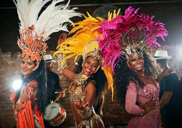 Carnival portrait and happy women with costume for dancing celebration and expression of Brazilian culture Festival people or tradition with dancers for performance creativity or energy at night