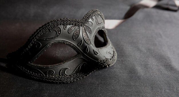 Carnival Venetian black mask on dark grey color background female disguise masquerade