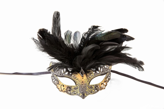 Photo carnival venetian mask with black feather decoration isolated on white