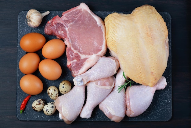 Carnivore diet concept Raw ingredients for zero carb diet meat poultry eggs on brown background