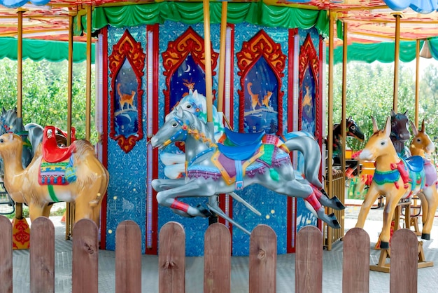 Carousel with colorful horses at amusement park Merry go round with horse Vintage ride attraction for children