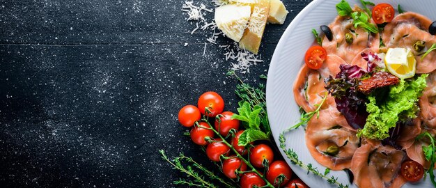 Foto carpaccio di pesce verdure formaggio spezie a fondo in legno vista dall'alto spazio libero