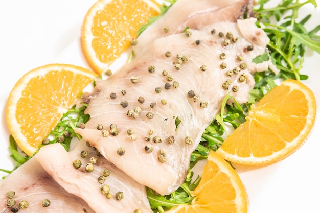 Photo carpaccio of fresh mediterranean swordfish with green pepper, chives and a few drops of orange juice