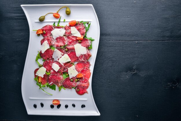 Carpaccio met vlees en groenten Italiaanse keuken Op een houten ondergrond Bovenaanzicht Vrije ruimte voor uw tekst