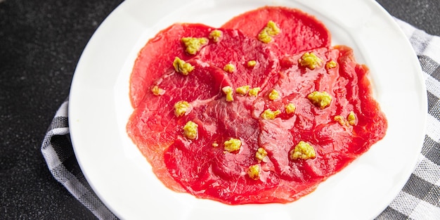 carpaccio raw meat spice appetizer olives, beef thin slices fresh healthy meal food snack