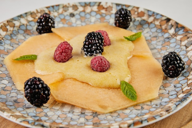 Carpaccio van meloen met verse frambozen en moerbeien aan boord