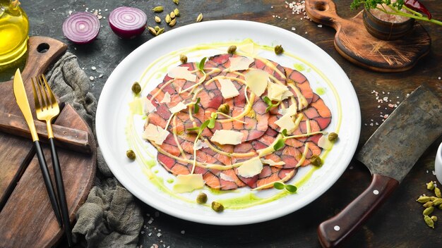 Carpaccio van zalm en tonijn met saus en kaas op een wit bord Bovenaanzicht Rustiek