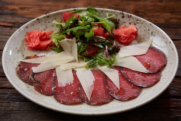 The carpaccio with cheese and salad top view