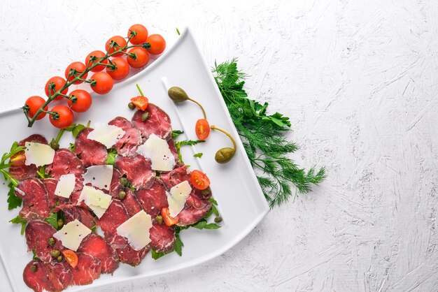 Carpaccio with meat and vegetables Italian cuisine On a wooden background Top view Free space for your text