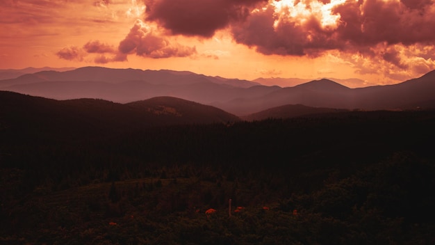 Carpathian Mountains Panorama of green hills in summer mountains Hazy green mountain forest under blue sky